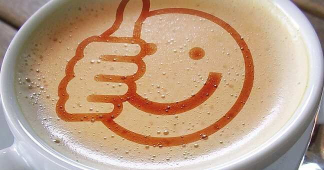 Smiley im Kaffeeschaum, Daumen hoch