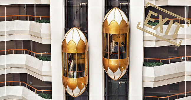 Panoramaaufzüge an Fassade in Gold und Weiß