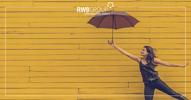 Frau vor gelber Wand hält Regenschirm von sich gestreckt