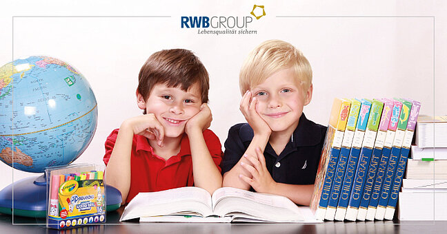 zwei Jungen zwischen Schulbüchern, Stiften und Globus