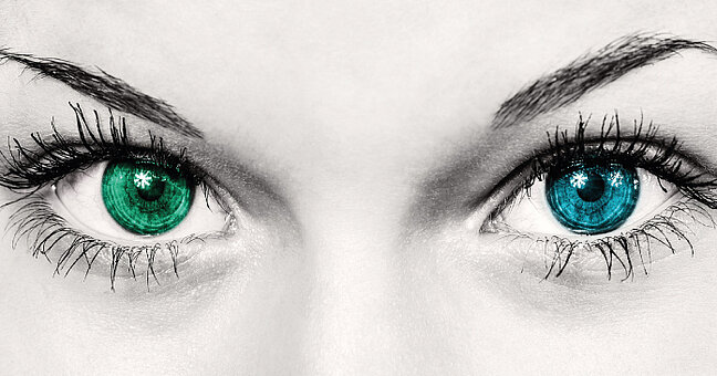 Ausschnitt eines Frauengesichts mit einem grünen und blauen Auge