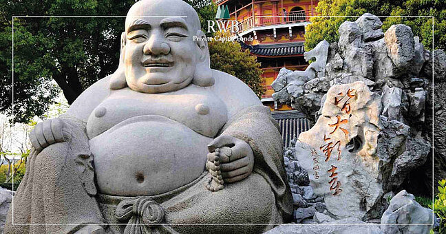 Buddha in Lebensgröße sitzt neben Brunnen aus Stein